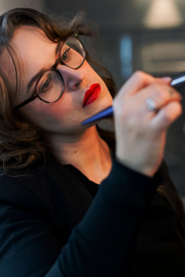 a woman holding a makeup brush
